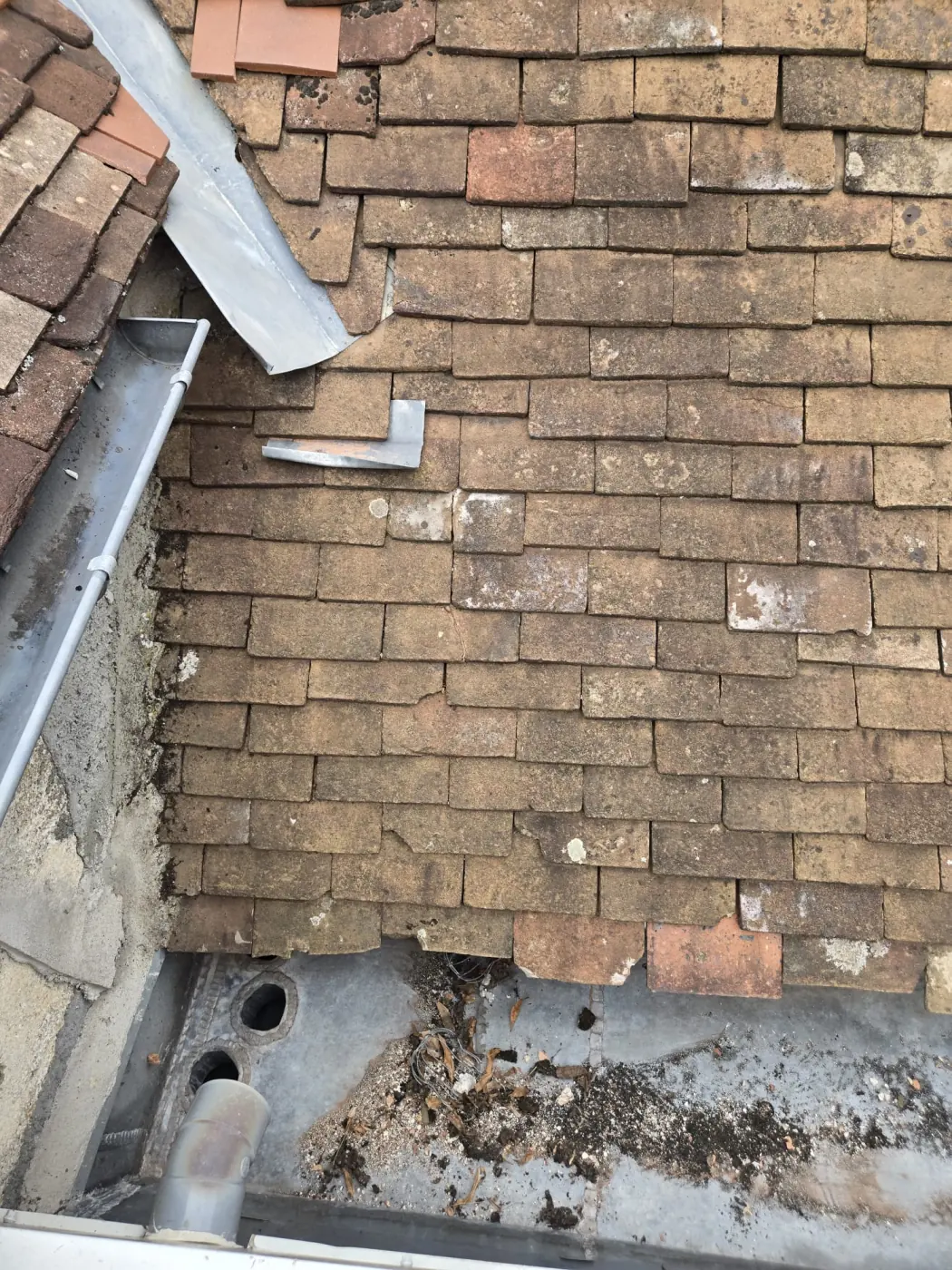 Toiture ancienne en tuiles avec gouttière zinc et zones sensibles